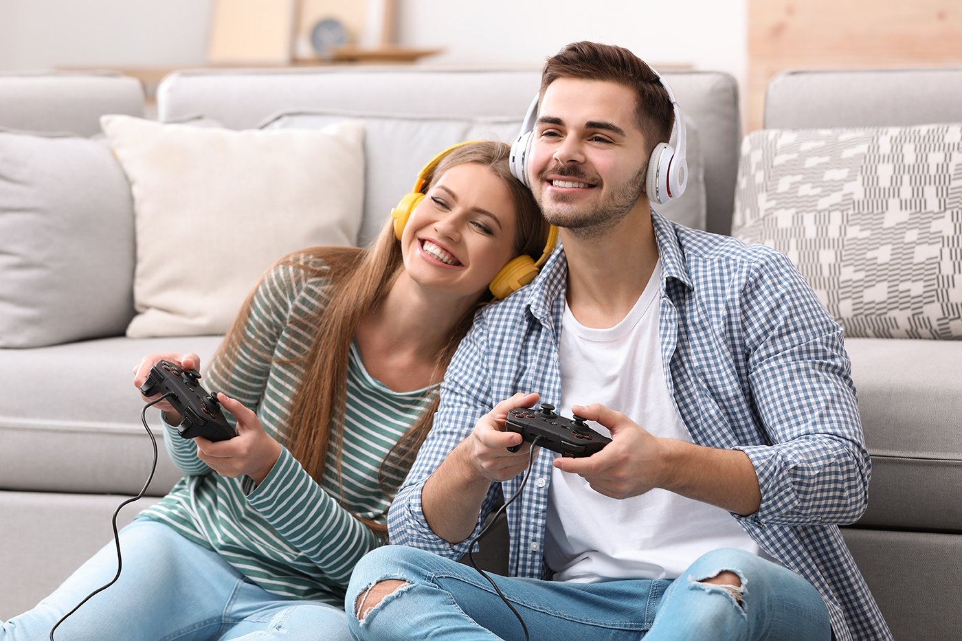 Pareja jugando videojuegos felices en el sofá